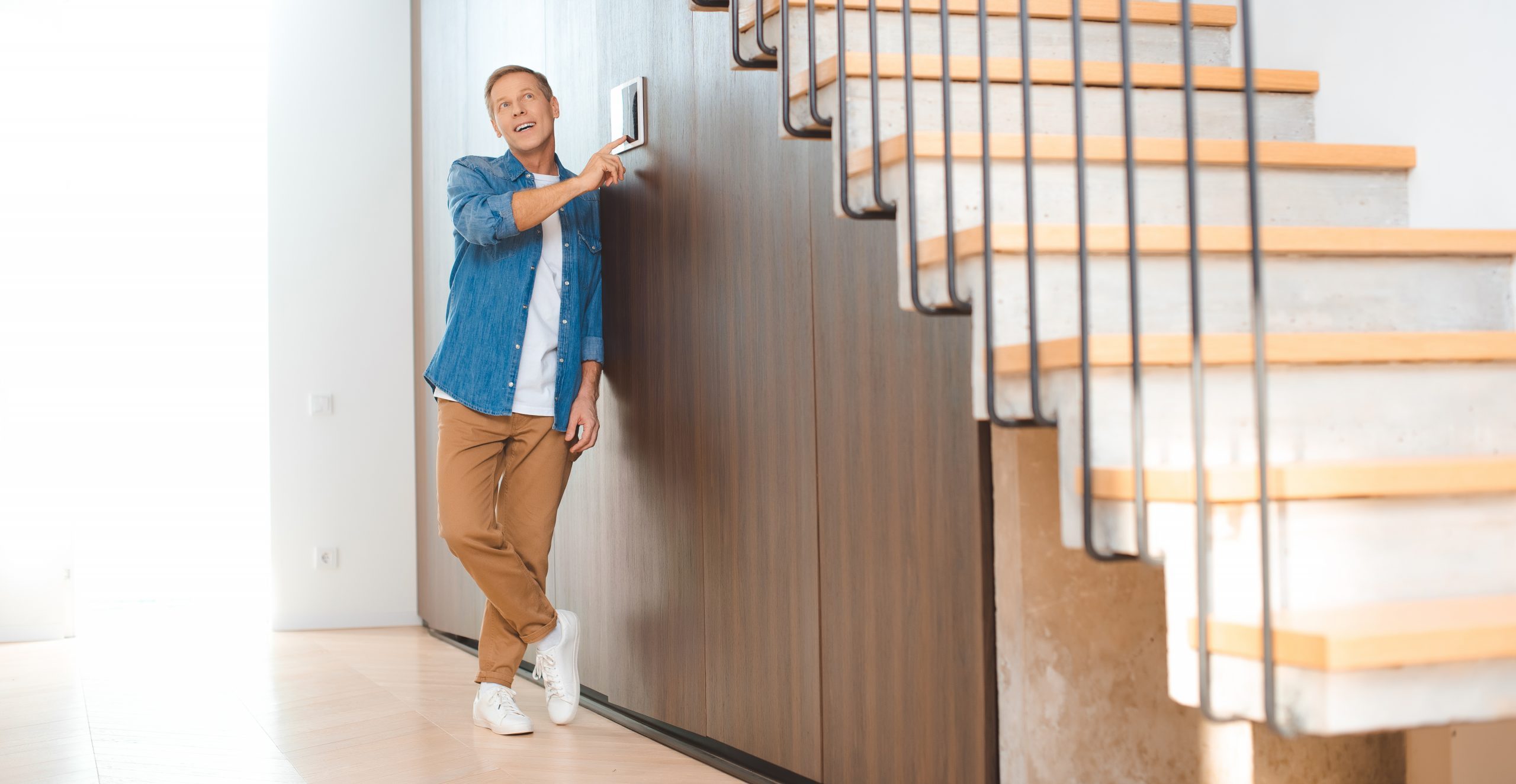 good-looking man using smart house control panel at new home
